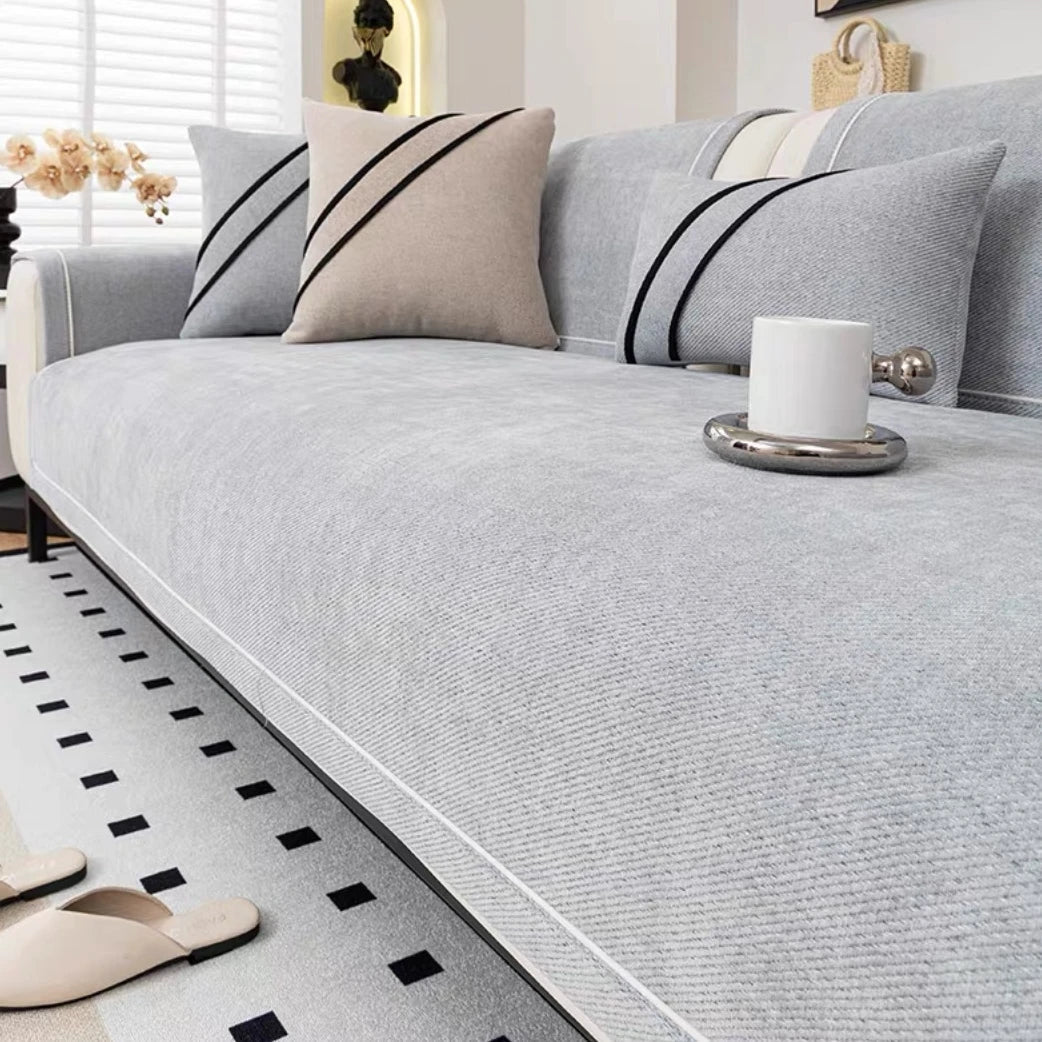 Light gray luxurious chenille sofa cover close-up on black-frame sofa - soft non-slip sofa cover