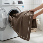 Brown luxurious chenille sofa cover being loaded into washing machine - machine washable sofa cover