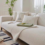 Cream ribbed sofa cover on white sofa with face cushions and folded sage green cover as accent