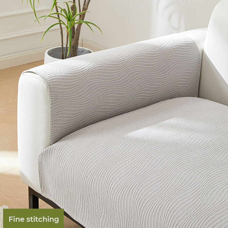 Beigei morandi chenille sofa cover on white sofa with fine stitching detail and indoor plant