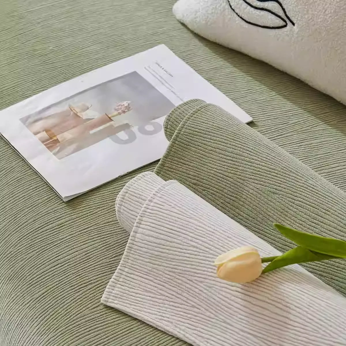 Sage green and cream morandi chenille sofa covers layered on sofa with tulip flower and magazine styling