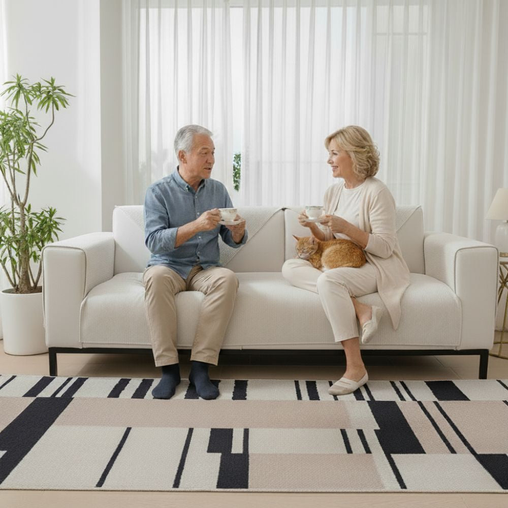 Elderly couple sitting on beigie Morandi Chenille sofa cover drinking tea with orange cat on lap