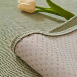 Sage green morandi chenille sofa cover folded back to reveal non-slip dotted underside with yellow tulip decoration