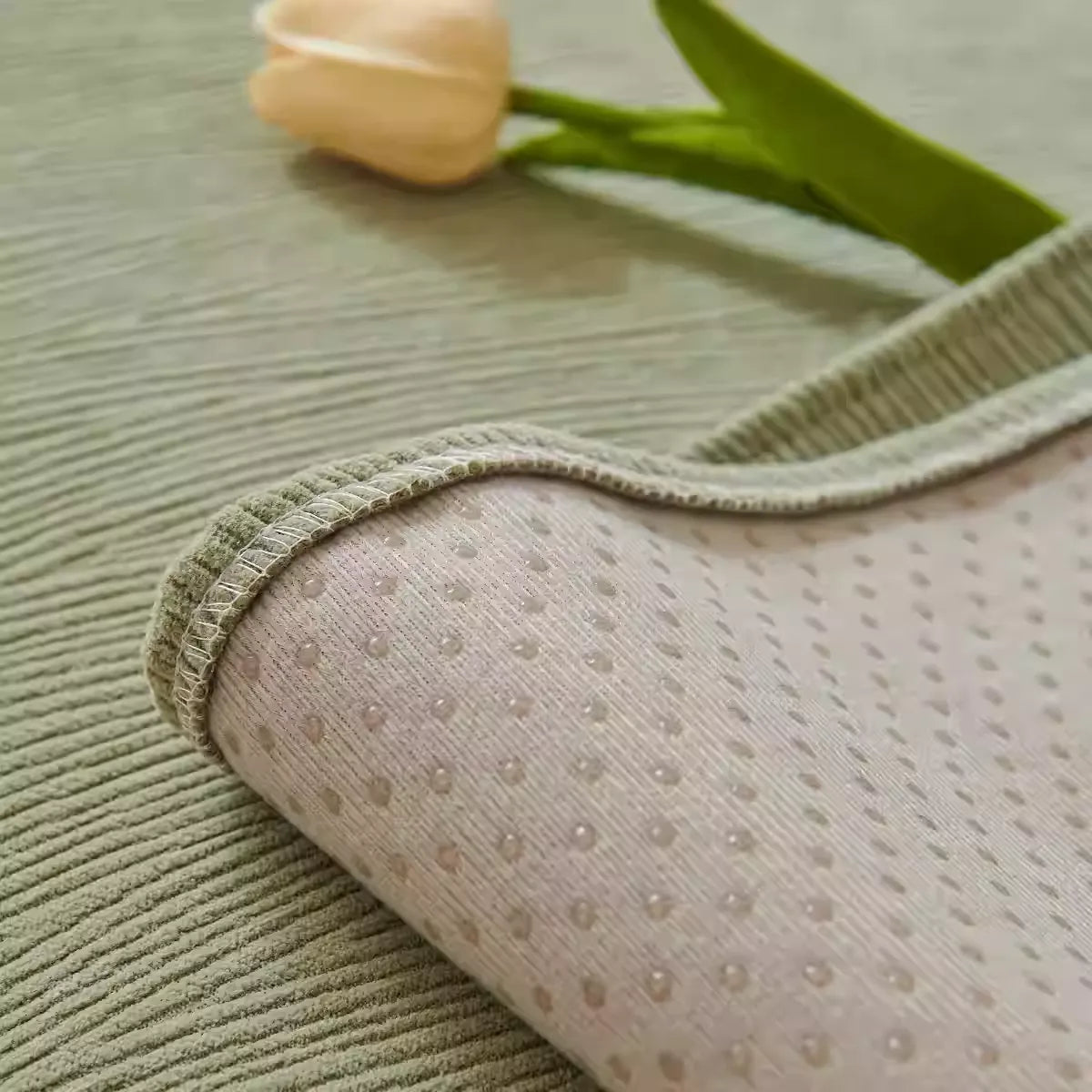 Sage green morandi chenille sofa cover folded back to reveal non-slip dotted underside with yellow tulip decoration